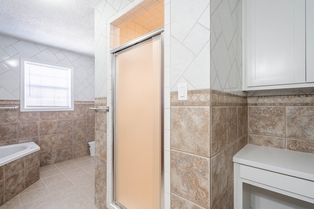 bathroom with tile walls, tile patterned floors, and plus walk in shower