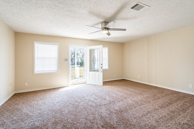 unfurnished room with a textured ceiling, ceiling fan, and carpet flooring