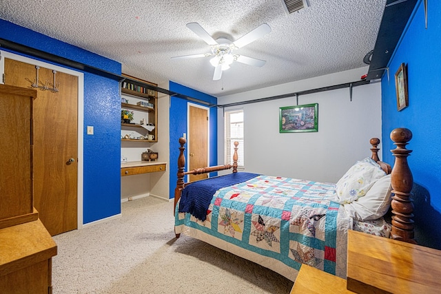 carpeted bedroom with visible vents, ceiling fan, a textured ceiling, and baseboards