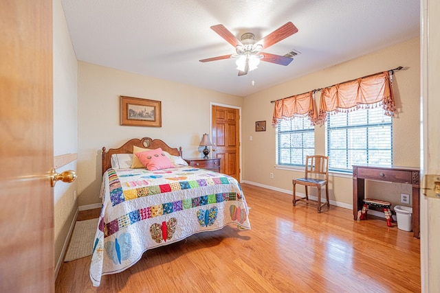 bedroom featuring visible vents, ceiling fan, a textured ceiling, wood finished floors, and baseboards