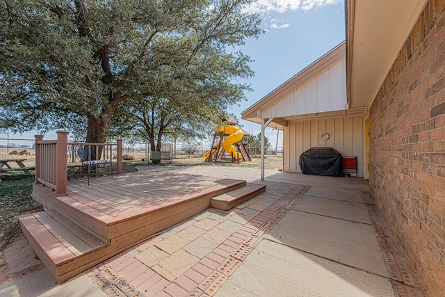 exterior space with a grill, fence, and a playground