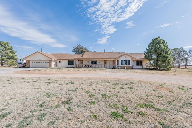 ranch-style house featuring driveway, board and batten siding, and an attached garage