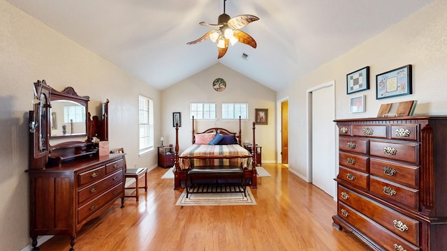 bedroom with light wood-style floors, lofted ceiling, visible vents, and baseboards