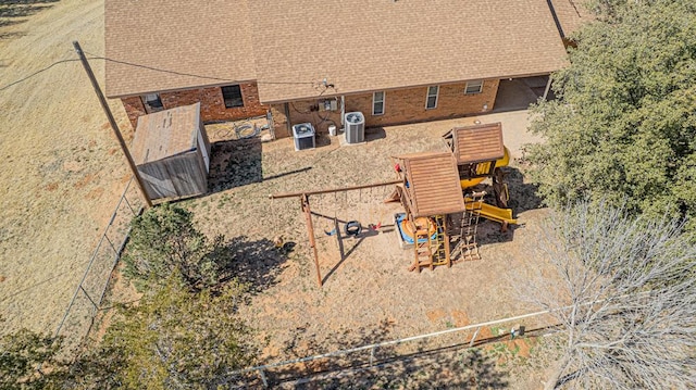 exterior space with a shingled roof and cooling unit