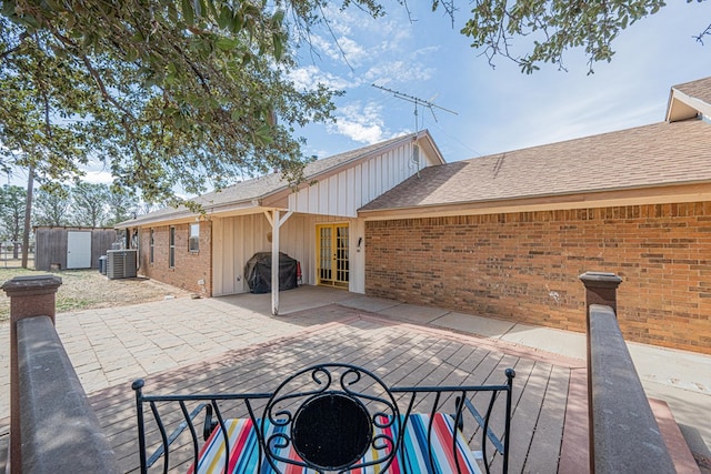 view of patio / terrace featuring central AC unit, a storage unit, an outdoor structure, and area for grilling