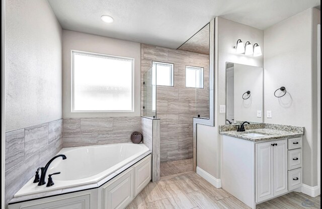 313 Peregrine Hill Cir, Midland, TX 79707 - bathroom featuring walk in shower, vanity, and a garden tub