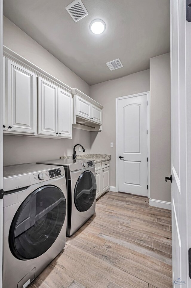 313 Peregrine Hill Cir, Midland, TX 79707 - washroom with washer and dryer, light wood finished floors, visible vents, and cabinet space