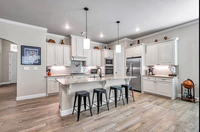 313 Peregrine Hill Cir, Midland, TX 79707 - kitchen with a breakfast bar, tasteful backsplash, white cabinetry, and appliances with stainless steel finishes