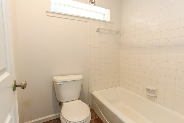 bathroom featuring baseboards, toilet, and washtub / shower combination