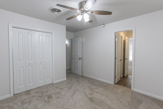 unfurnished bedroom featuring a closet, carpet flooring, baseboards, and visible vents