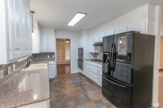 kitchen featuring under cabinet range hood, decorative backsplash, white cabinets, black appliances, and a sink