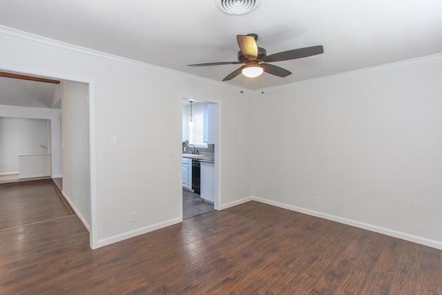 spare room with visible vents, a sink, dark wood-style floors, crown molding, and baseboards