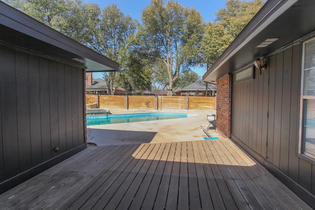 wooden deck with a fenced in pool, a fenced backyard, and a patio area