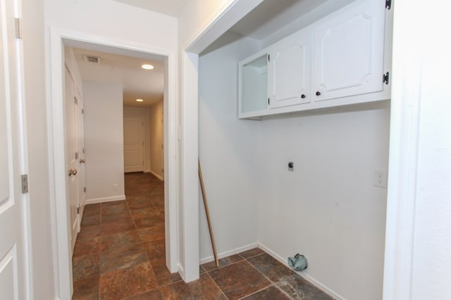 clothes washing area featuring visible vents, stone finish flooring, cabinet space, baseboards, and hookup for an electric dryer