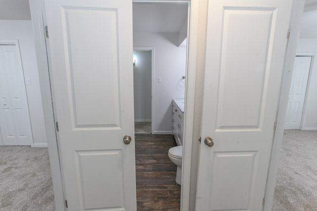 bathroom with toilet, vanity, and baseboards