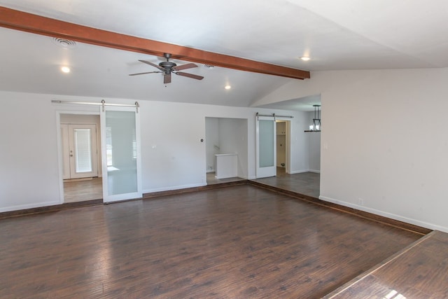 spare room featuring a ceiling fan, wood finished floors, baseboards, lofted ceiling with beams, and a barn door