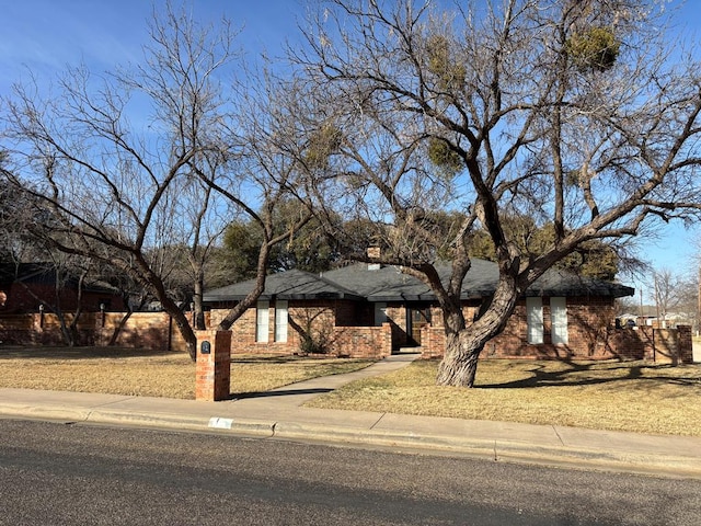 view of front of home with a front lawn and brick siding