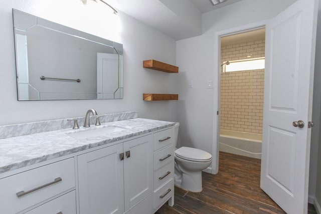 bathroom with tub / shower combination, toilet, wood finished floors, and vanity