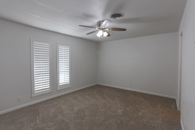 spare room with a ceiling fan, carpet, visible vents, and baseboards