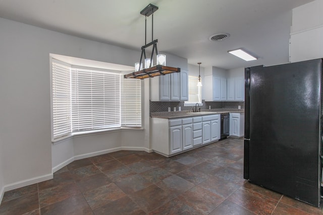 kitchen with visible vents, backsplash, baseboards, black appliances, and a sink