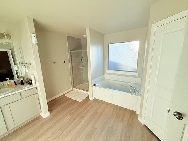 bathroom featuring plus walk in shower, wood-type flooring, and vanity