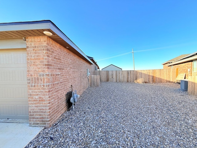 view of yard featuring a garage and central AC