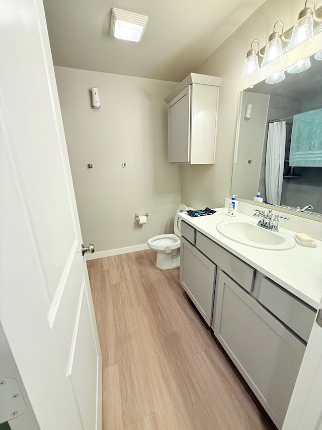 bathroom with vanity, hardwood / wood-style floors, toilet, and walk in shower