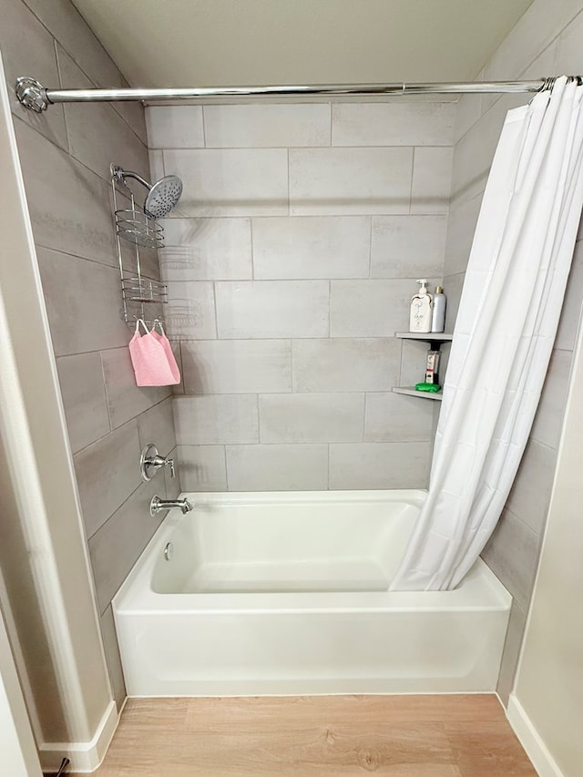 bathroom with shower / tub combo and wood-type flooring