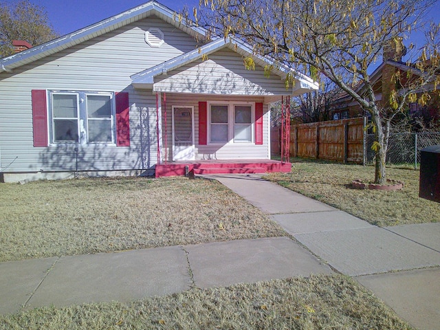 bungalow-style house featuring covered porch and a front lawn