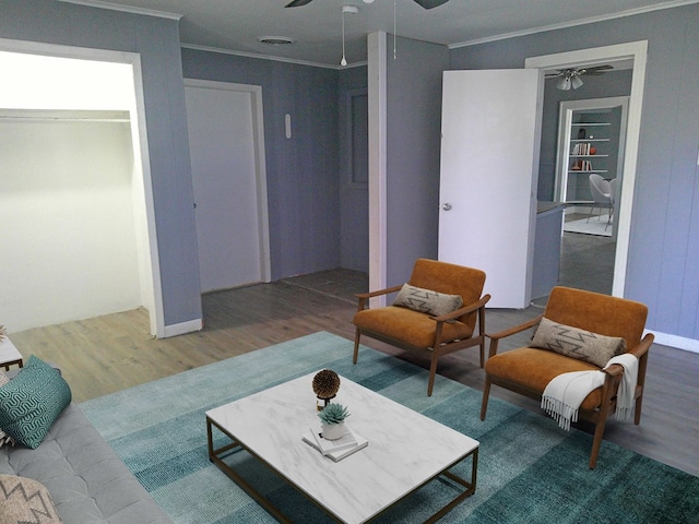 living room featuring ceiling fan, crown molding, built in shelves, and hardwood / wood-style flooring