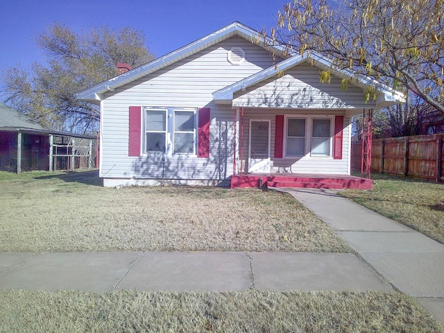 bungalow-style house featuring covered porch and a front lawn