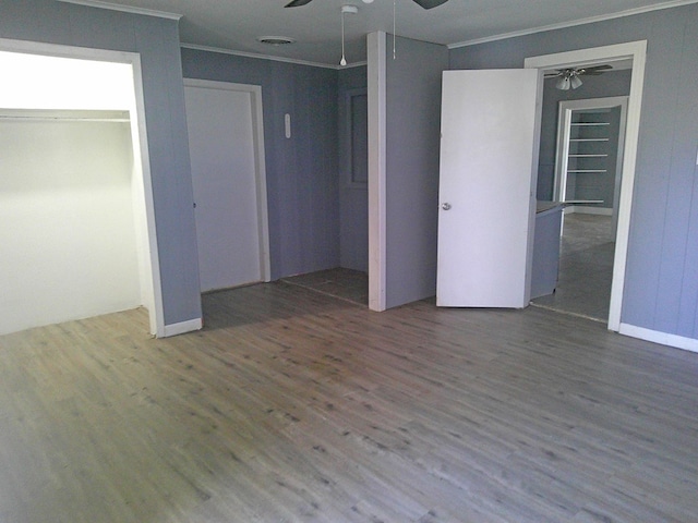 unfurnished bedroom with ceiling fan, ornamental molding, and wood-type flooring