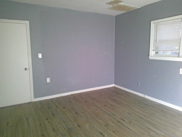 unfurnished room with dark hardwood / wood-style flooring