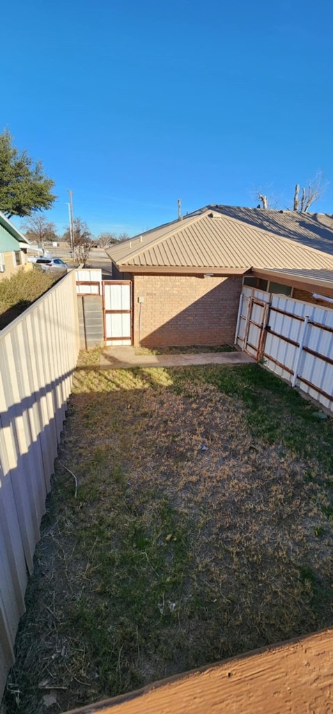 view of yard featuring a fenced backyard and a gate