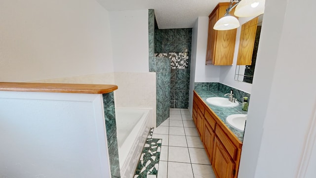 bathroom featuring a garden tub, double vanity, a sink, a textured ceiling, and tile patterned floors