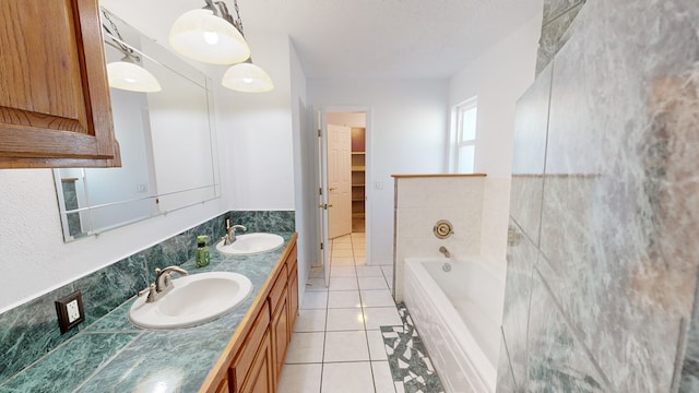 bathroom with double vanity, a sink, a bath, and tile patterned floors