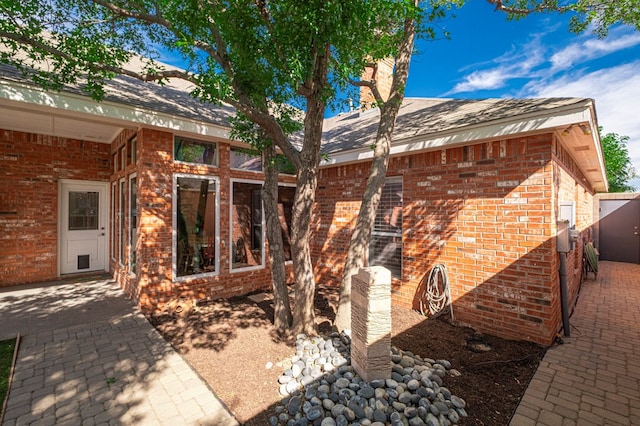exterior space with a patio area and brick siding