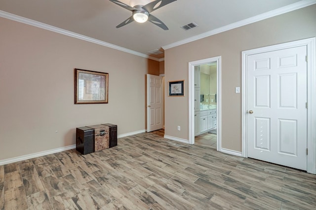 interior space featuring visible vents, ornamental molding, light wood-style flooring, and baseboards