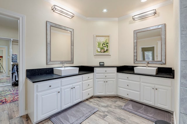 bathroom featuring vanity, ornamental molding, and wood finished floors
