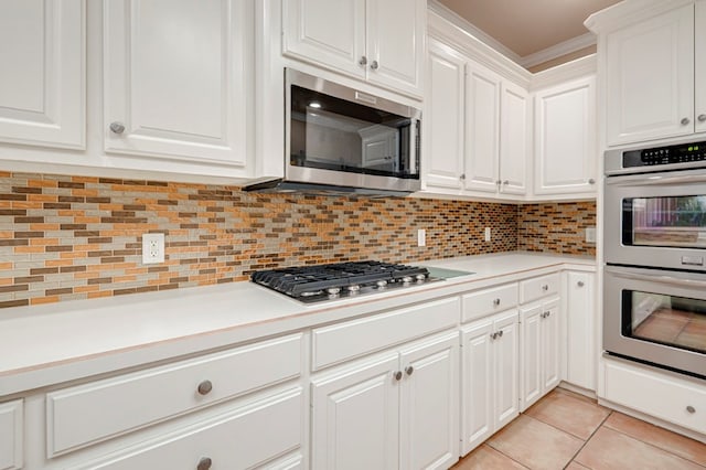 kitchen with light countertops, decorative backsplash, white cabinets, and stainless steel appliances