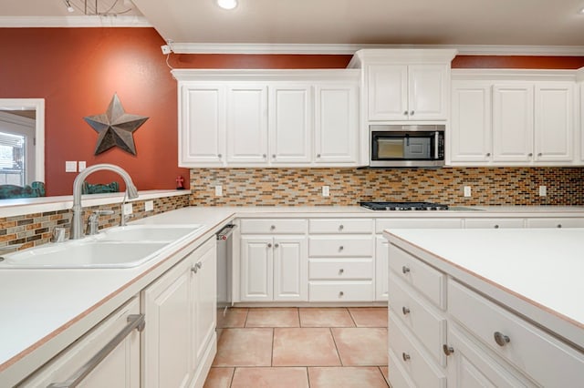 kitchen featuring decorative backsplash, light countertops, white cabinetry, a sink, and stainless steel appliances