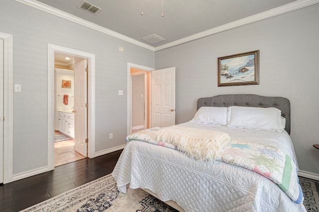 bedroom featuring visible vents, crown molding, baseboards, ensuite bathroom, and hardwood / wood-style floors