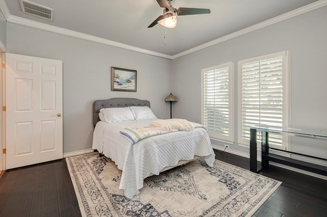bedroom featuring ceiling fan, visible vents, crown molding, dark wood finished floors, and baseboards