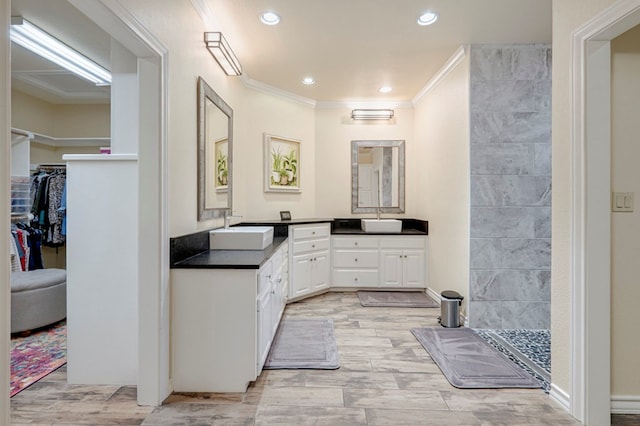 bathroom with crown molding, a tile shower, wood finished floors, vanity, and recessed lighting