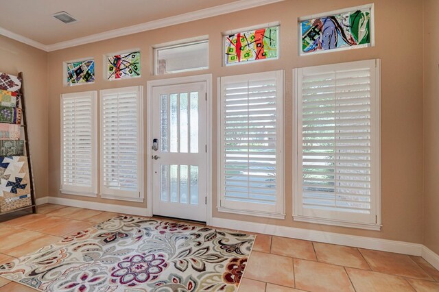 entryway featuring baseboards, tile patterned flooring, ornamental molding, and visible vents