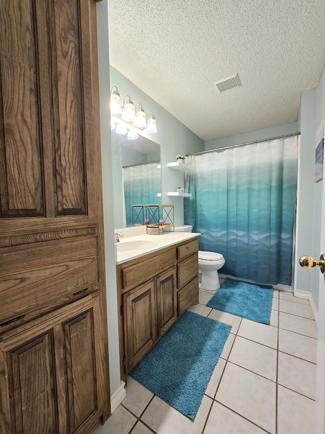 bathroom featuring tile patterned floors, toilet, vanity, and a textured ceiling