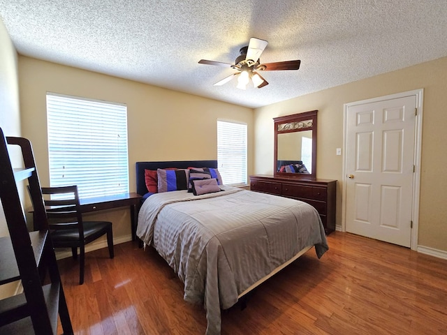 bedroom featuring ceiling fan, dark hardwood / wood-style flooring, and a textured ceiling