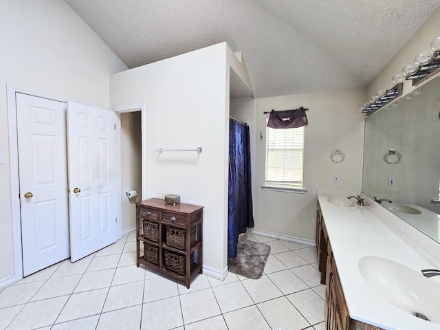 bathroom featuring tile patterned flooring, vanity, vaulted ceiling, and a textured ceiling