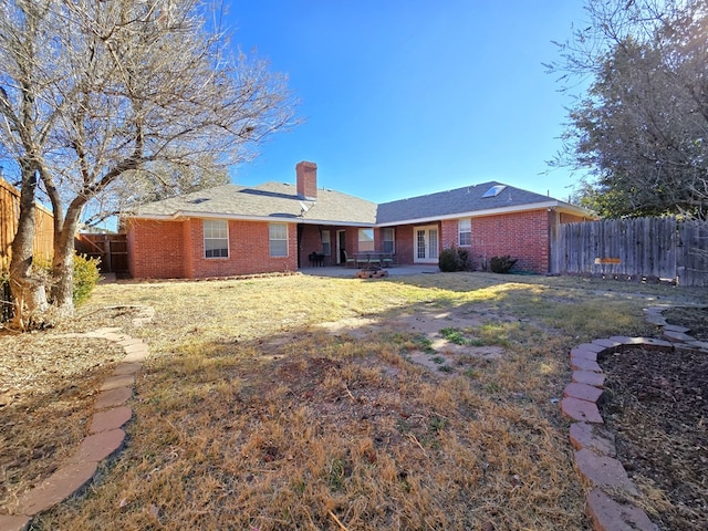 rear view of house featuring a lawn