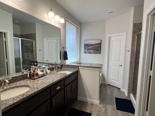 8409 E County Rd 113, Midland, TX 79706 - bathroom with a shower stall, wood finished floors, double vanity, and a garden tub
